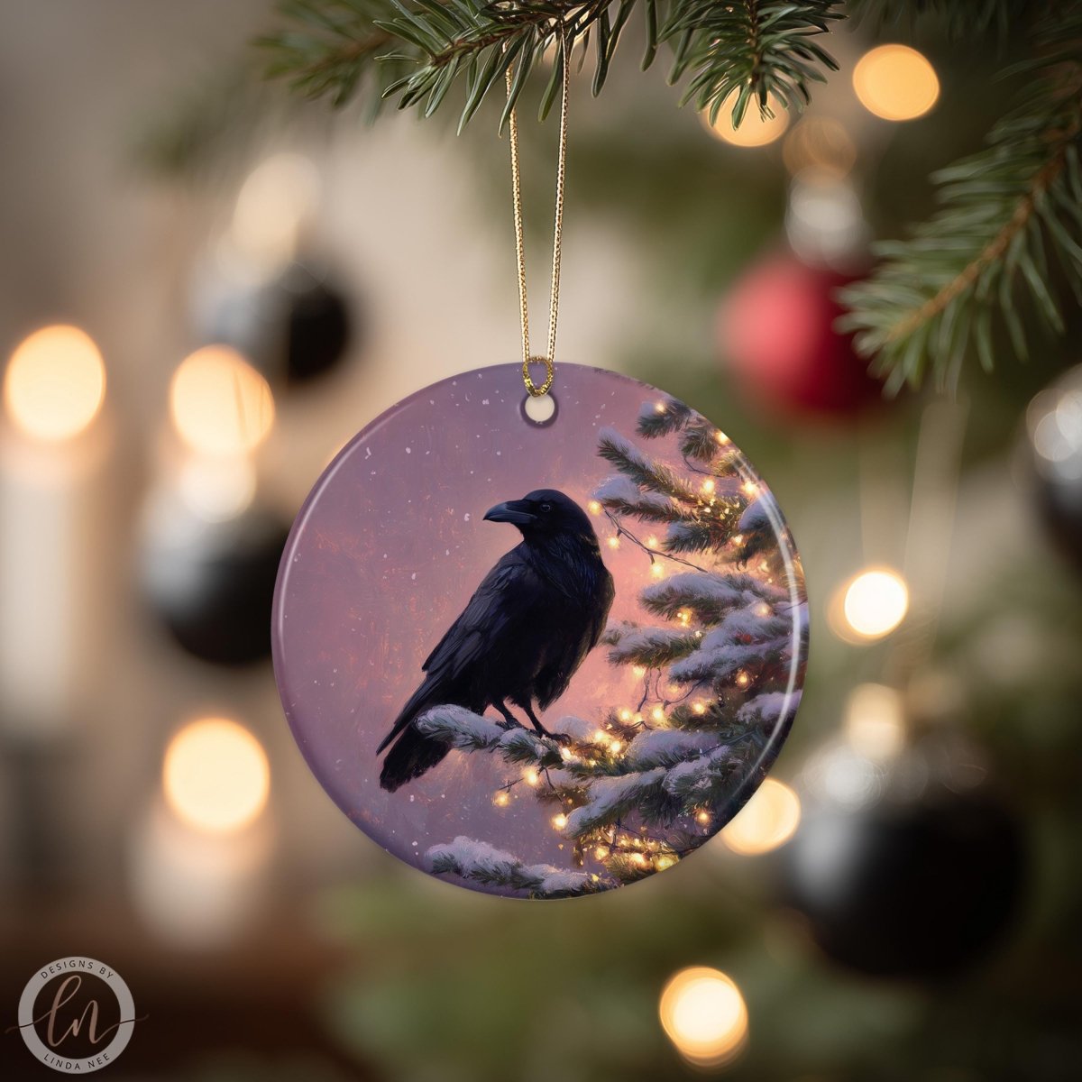 A black bird is perched on a snowy branch of a Christmas tree, with twinkling lights and ornaments in the background.