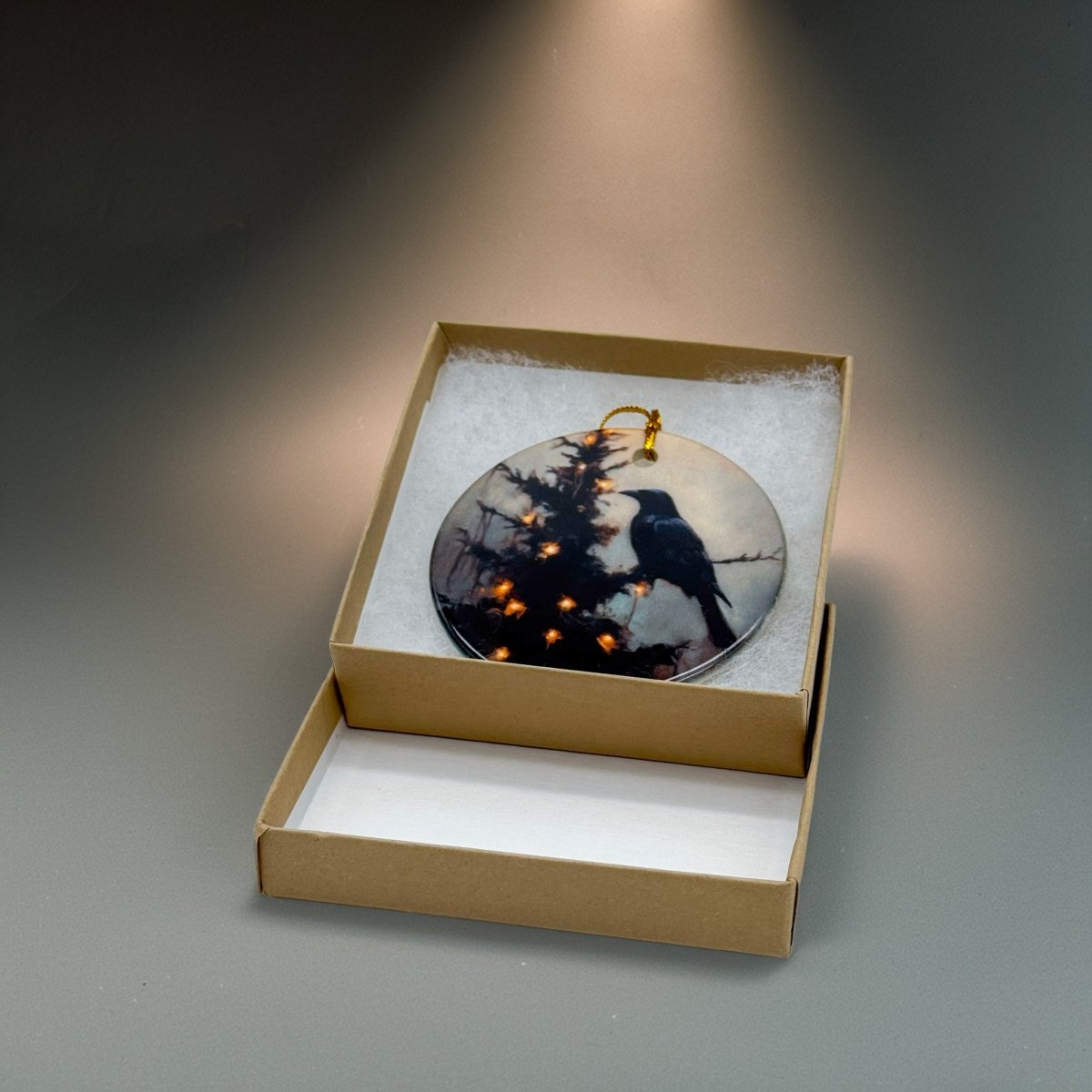Dark academia raven Christmas ornament in kraft box with moody light and holiday glow