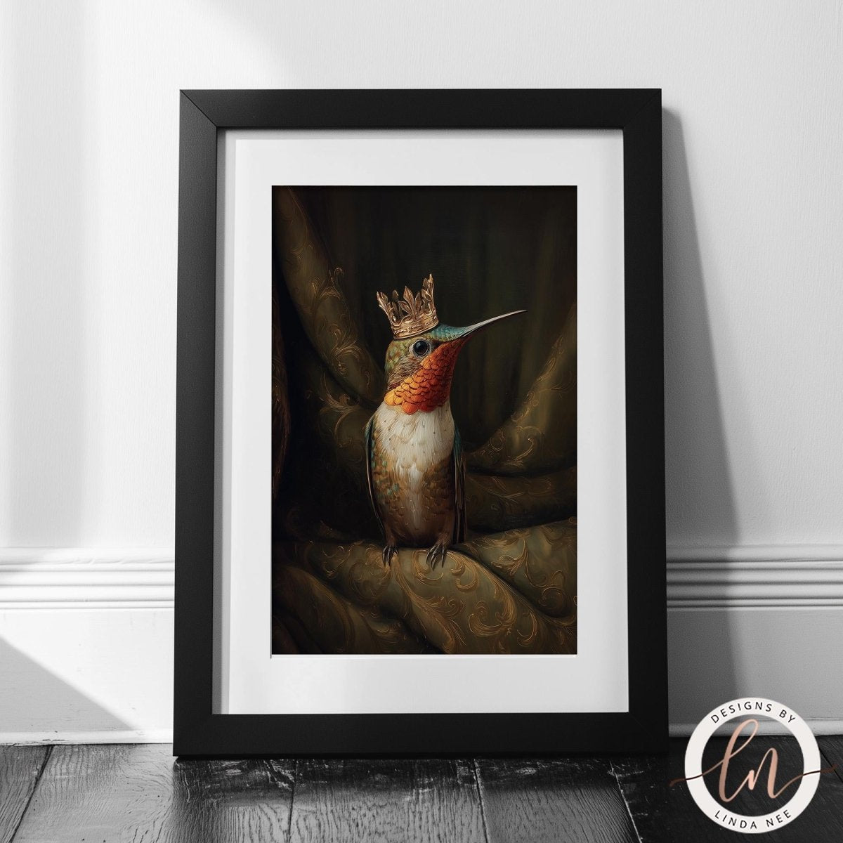 A framed painting of a colorful hummingbird wearing a golden crown, sitting on a green fabric.