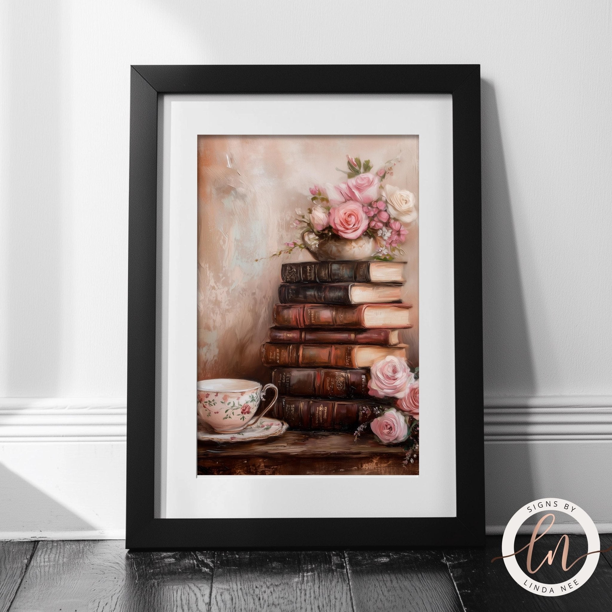 A framed image depicting a stack of old books with a teacup and pink roses on a wooden surface.
