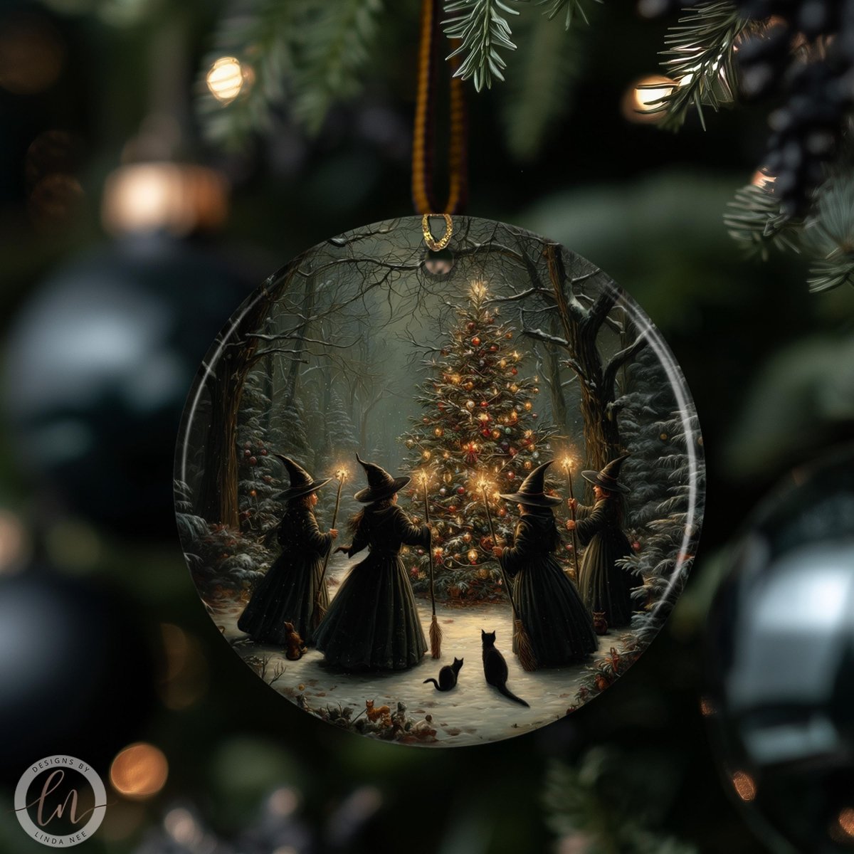 A glass ornament depicting a group of witches in black dresses and hats standing in front of a Christmas tree, with a cat walking on the snow.