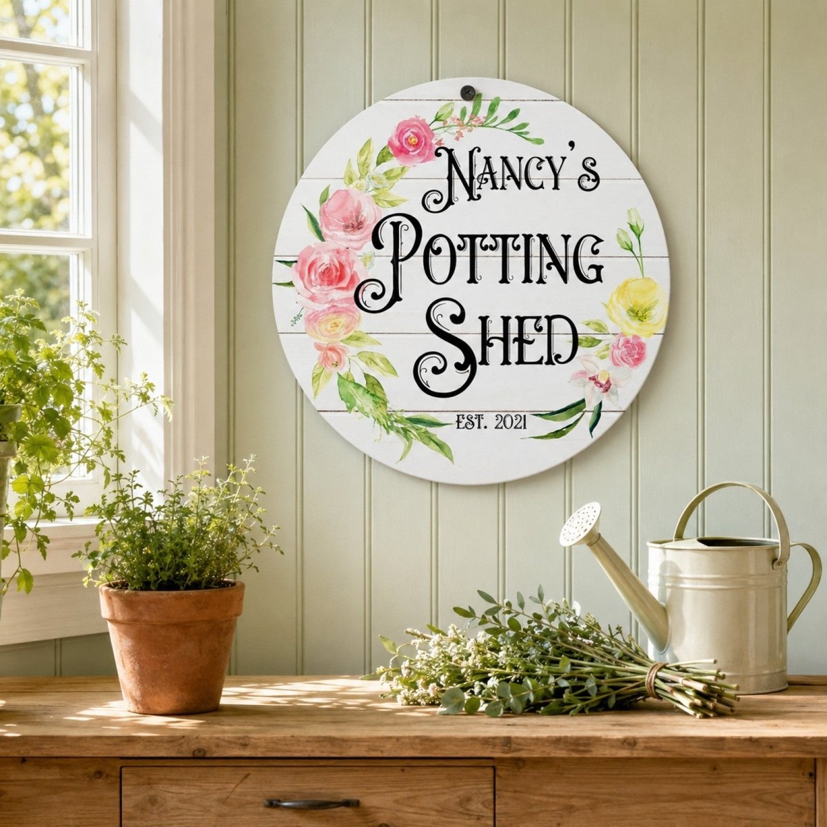 Personalized floral potting shed metal sign displayed in a bright garden studio.
