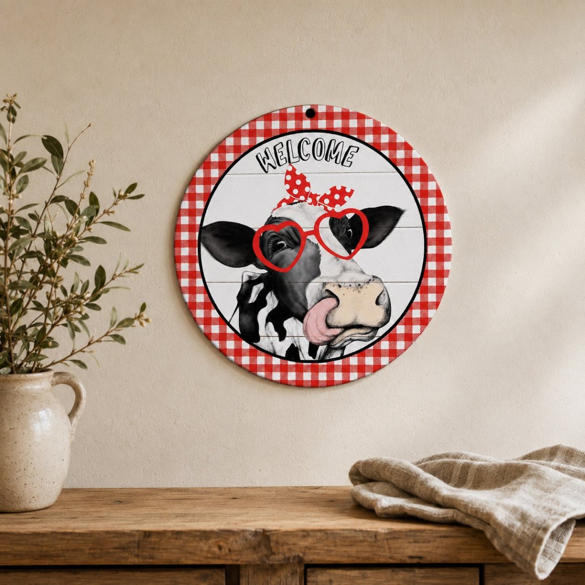 Round farm animal metal sign displayed on a rustic wooden wall above a console table in a naturally lit farmhouse interior.