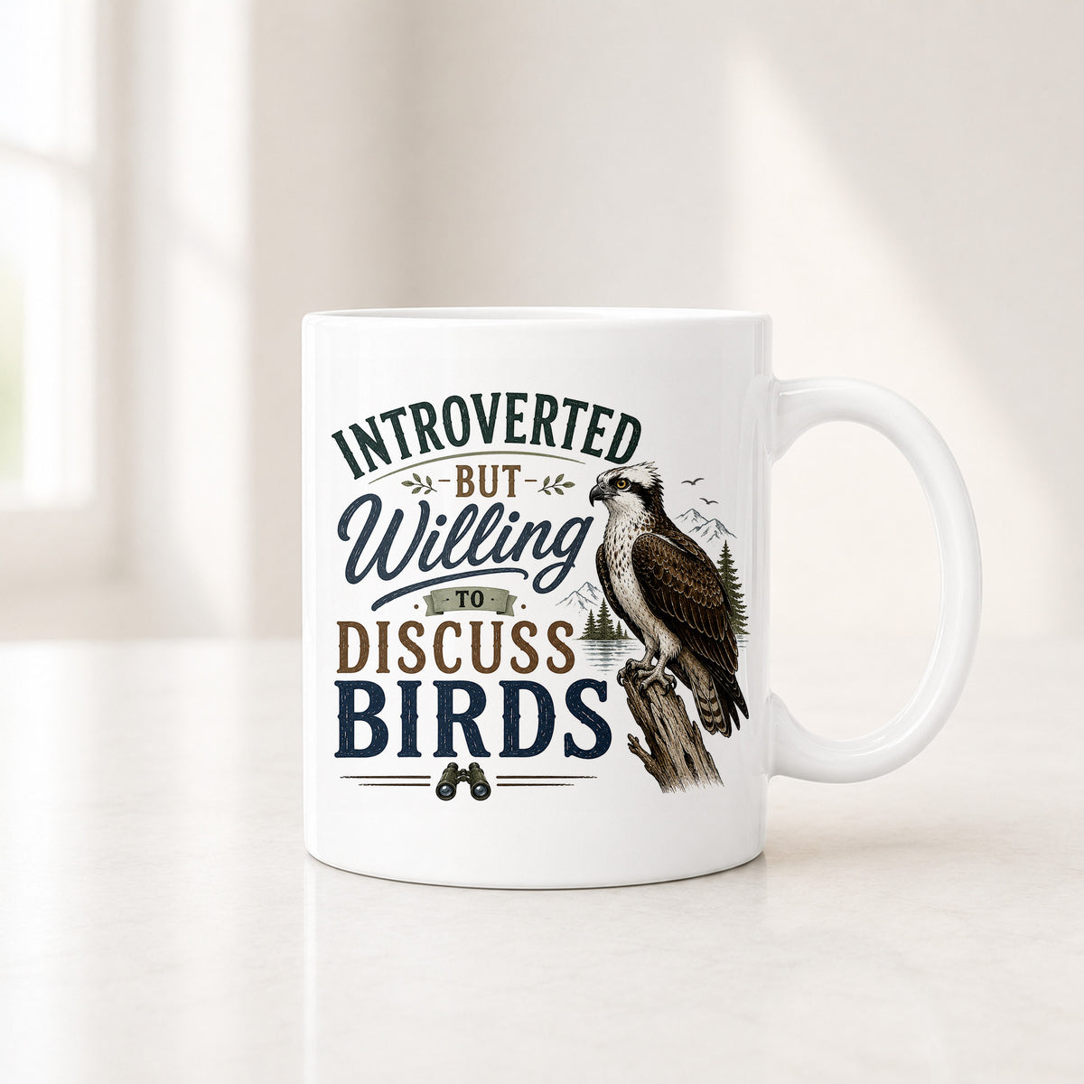 11 oz white mug with the quote Introverted But Willing to Discuss Birds in navy and brown beside an osprey