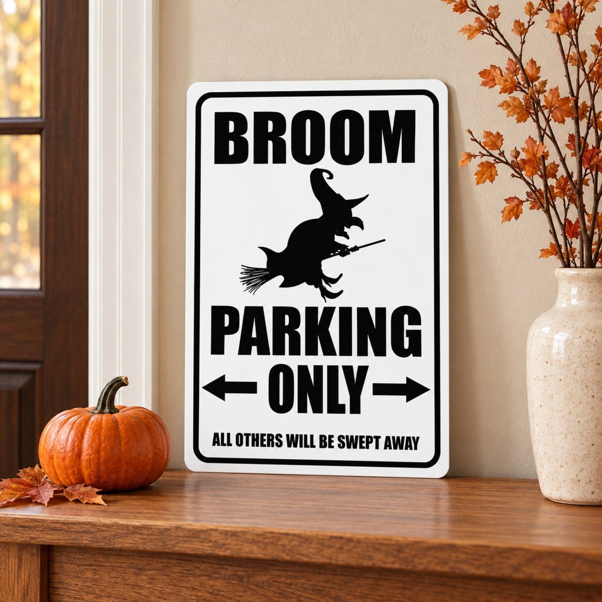 Broom Parking Only witch sign on a wood shelf with a pumpkin and orange leaves