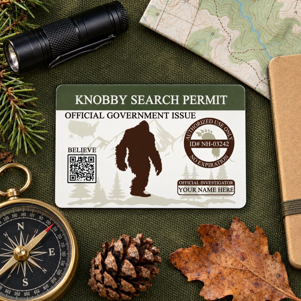 a Knobby Search Permit, a government-issued identification card, surrounded by various outdoor items such as a compass, pine cones, and a leaf.