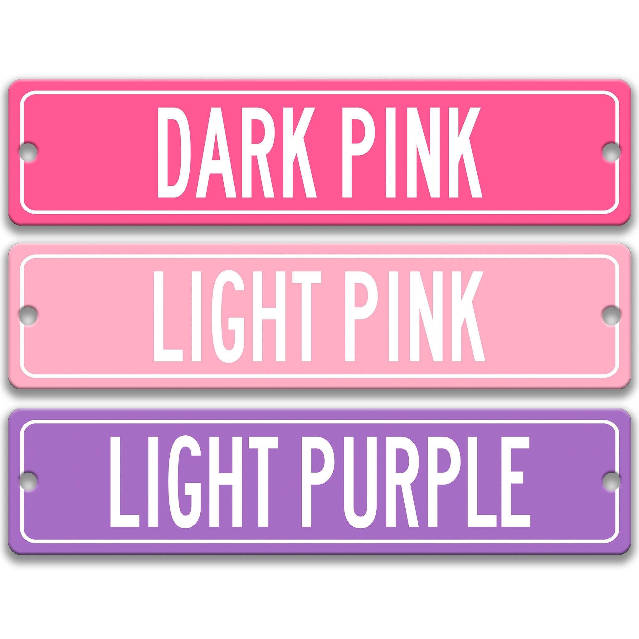 three rectangular signs with different colors: dark pink, light pink, and light purple.