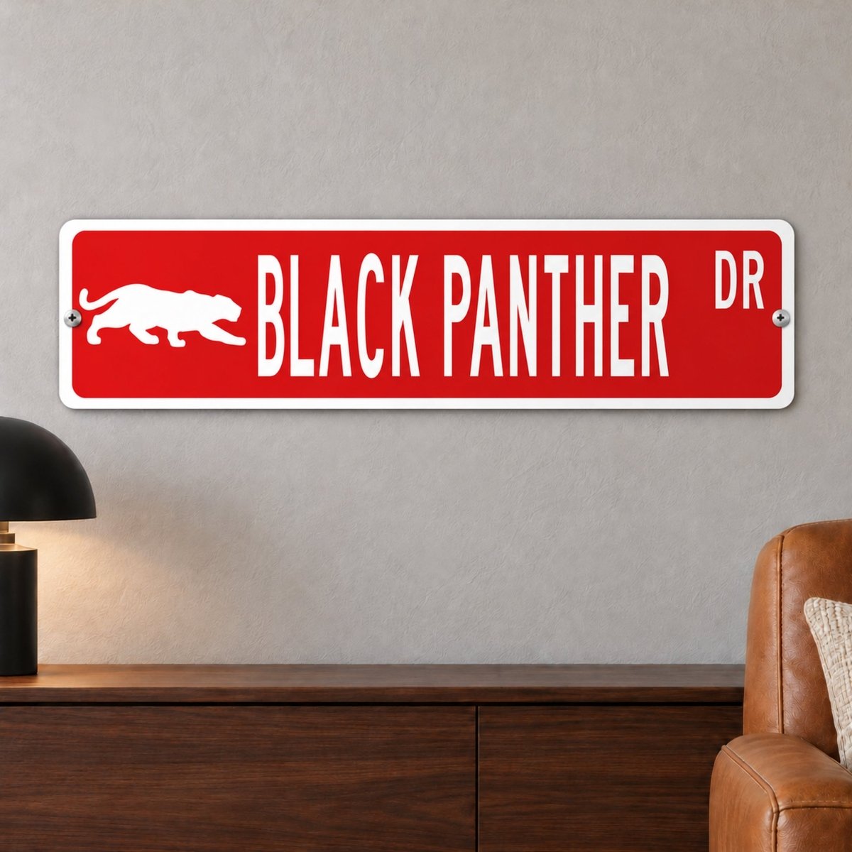 Black Panther street sign with a red background reading BLACK PANTHER DR with a prowling panther silhouette, hanging on a wall
