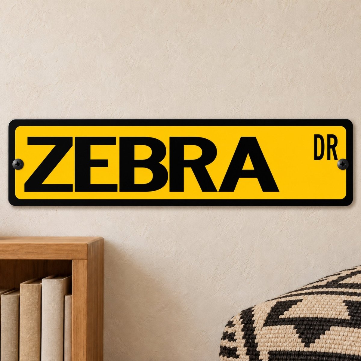 Zebra street sign with a yellow background reading ZEBRA DR, hanging on a wall
