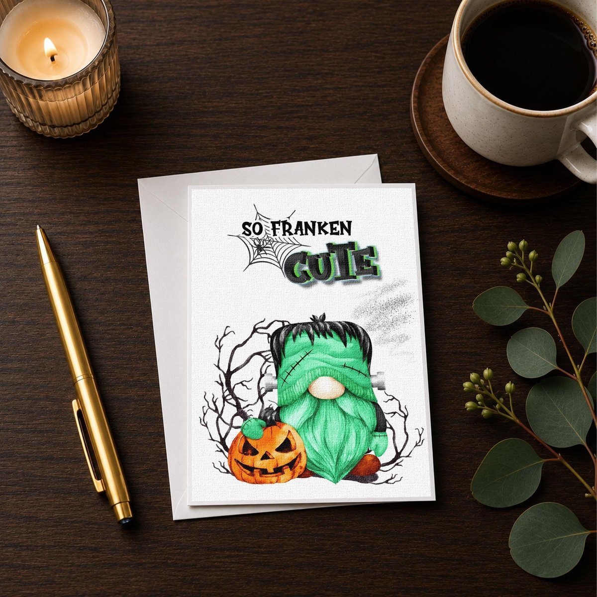 a Halloween-themed greeting card with a green gnome and a jack-o-lantern, accompanied by a candle and a cup of coffee on a wooden surface.