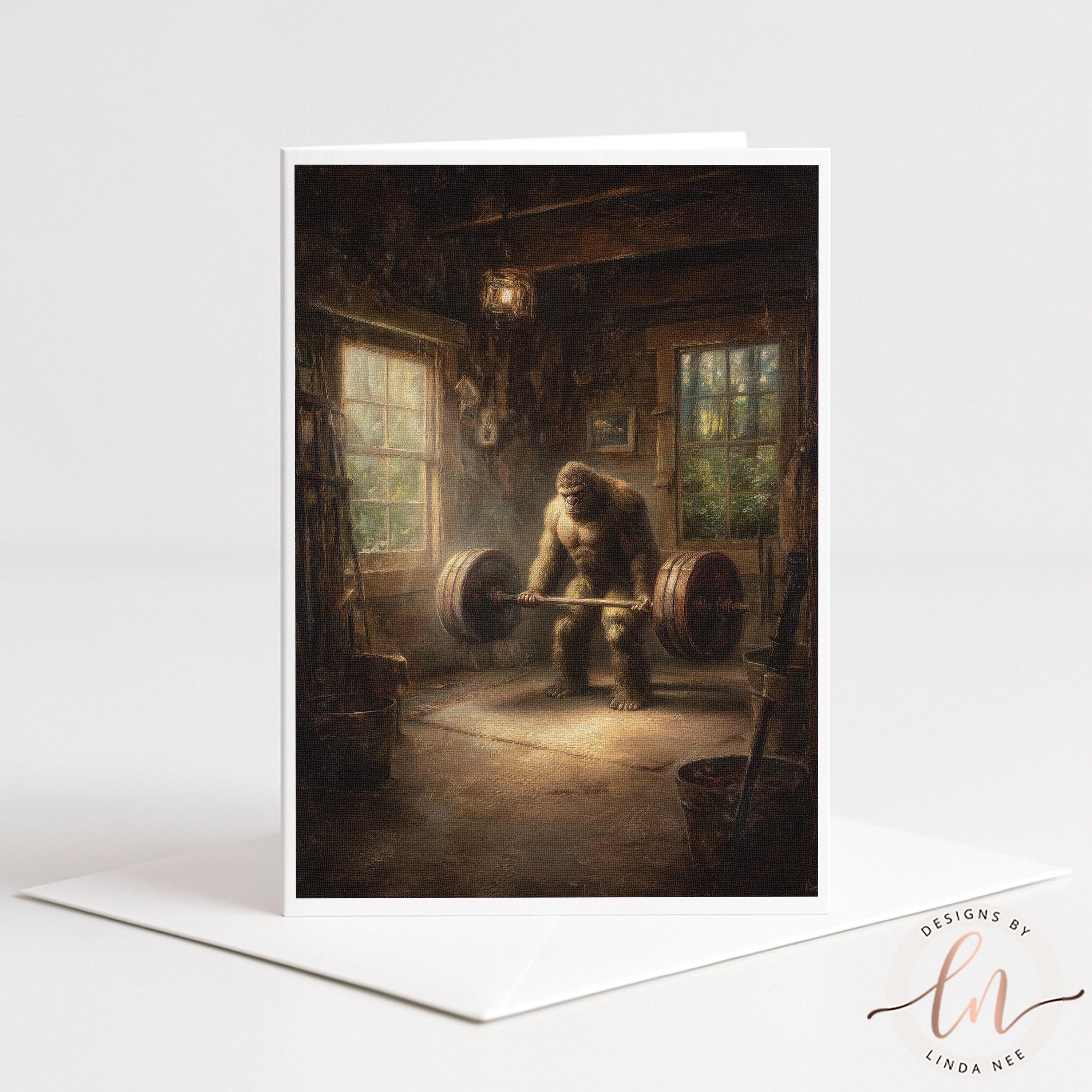 Greeting card by Linda Nee featuring Bigfoot deadlifting a heavily loaded barbell inside a rustic cabin gym with warm window light, wood beams, and a moody strength-training atmosphere.