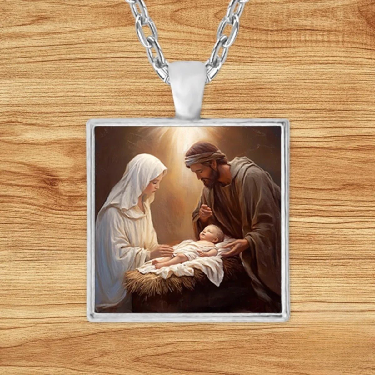 Square silver charm pendant necklace featuring Mary, Joseph, and Baby Jesus rendered in classical religious oil painting style