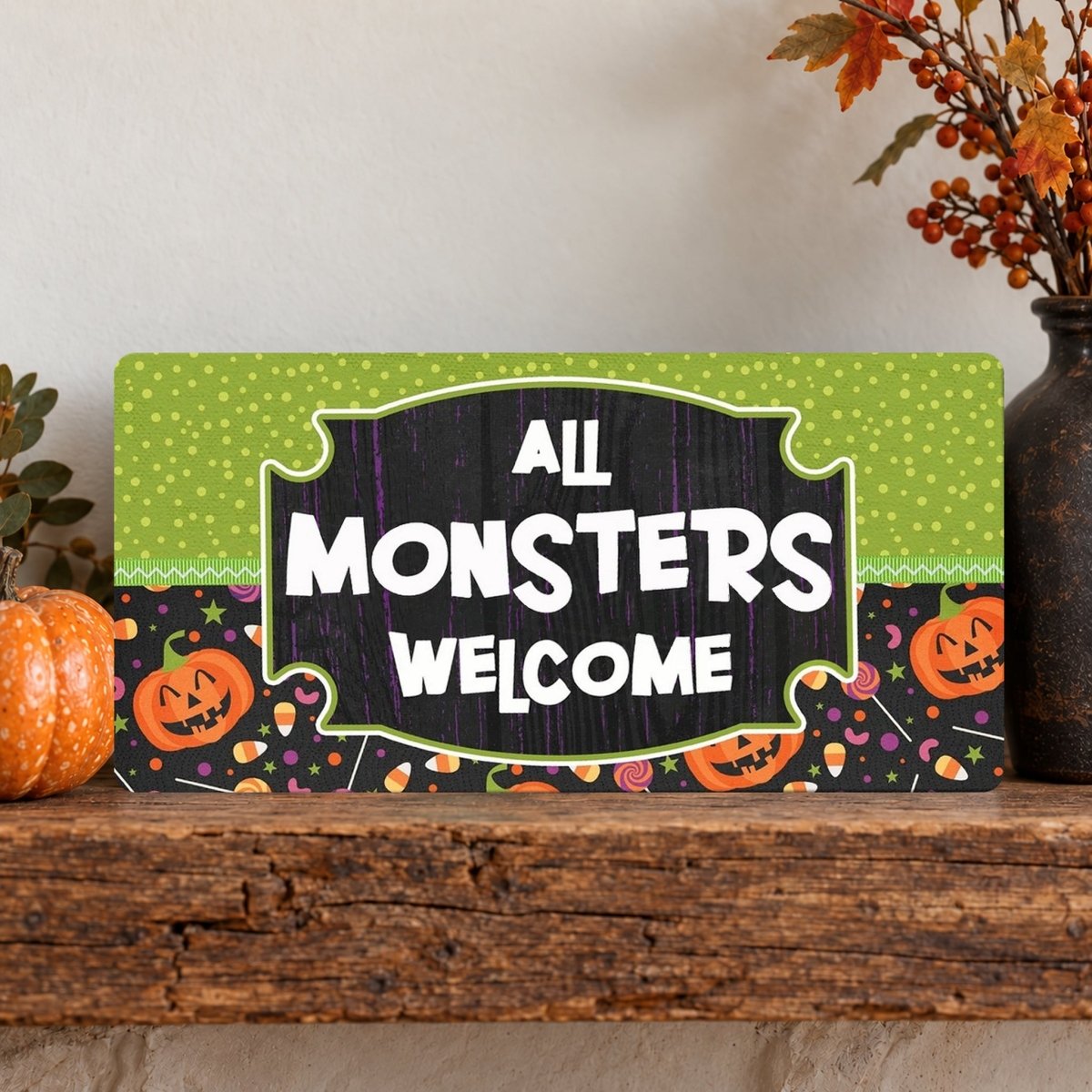 Polka Dot All Monsters Welcome sign on a shelf with fall decor