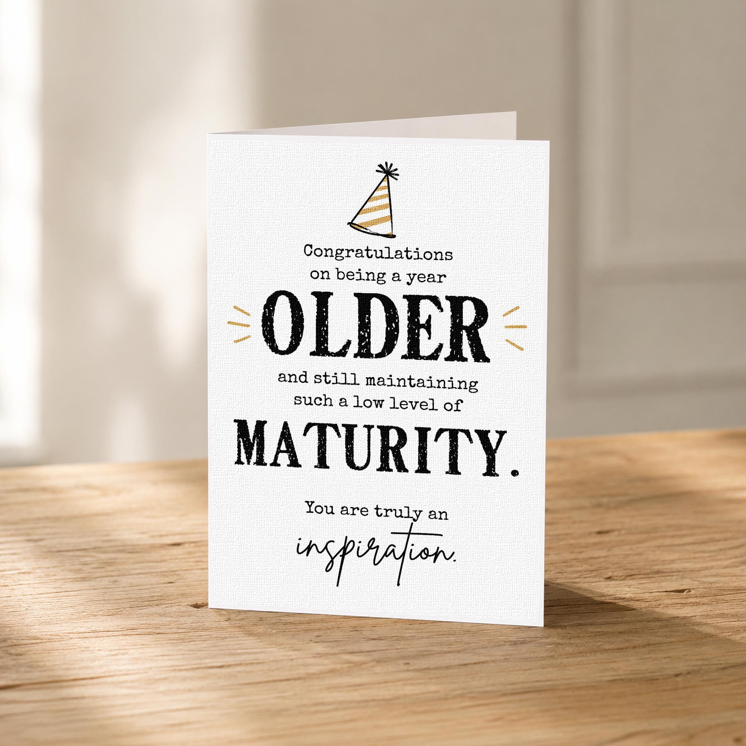 a greeting card with a humorous message about an older person maintaining a low level of maturity.