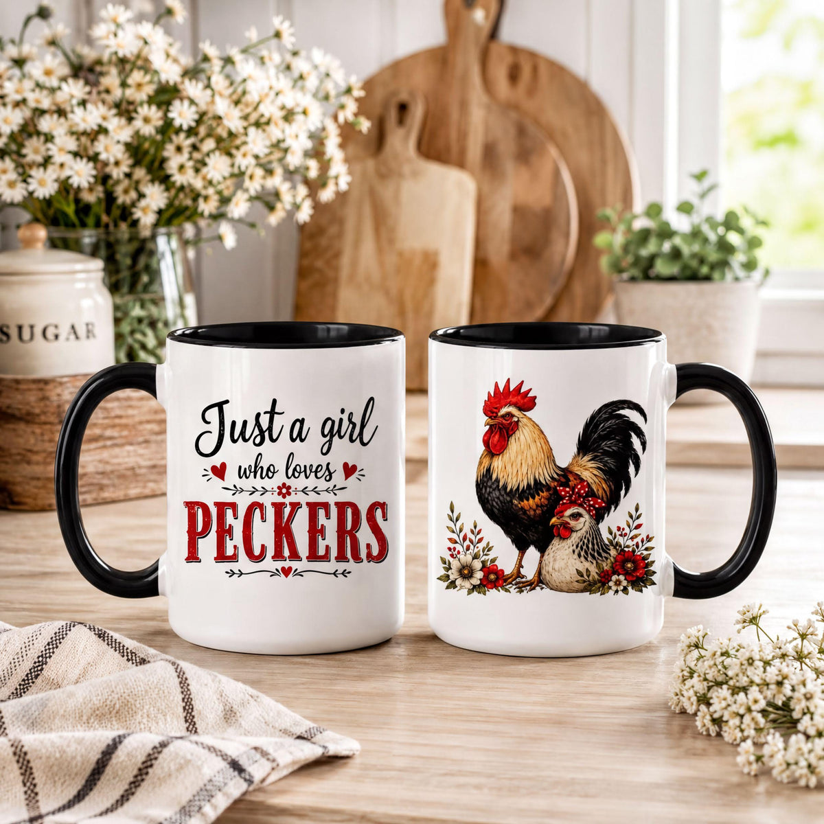 Two black handle rooster mugs on a kitchen counter with baby's breath, cutting boards and a sugar canister