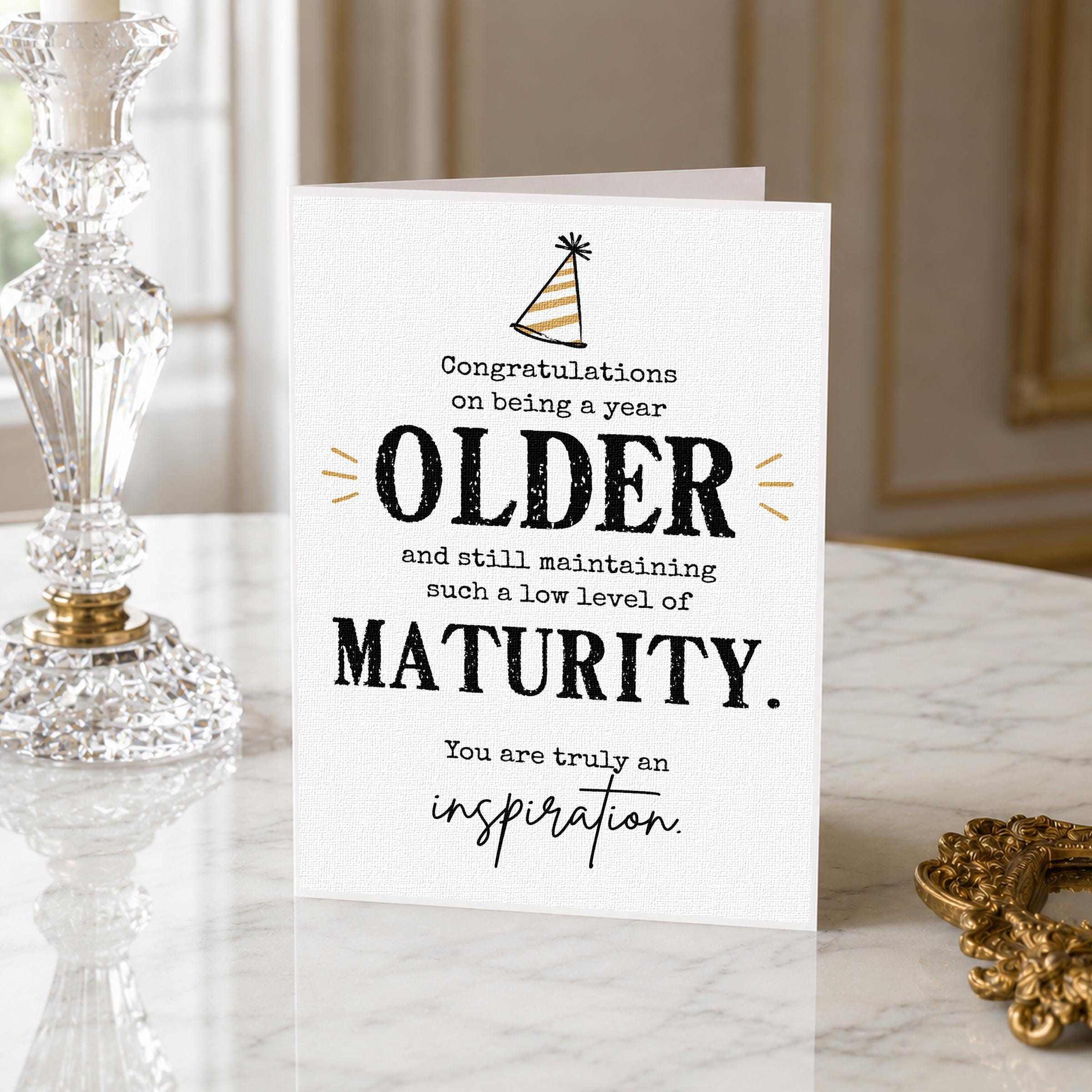 a card with a congratulatory message for an older person, placed on a marble surface next to a crystal vase.