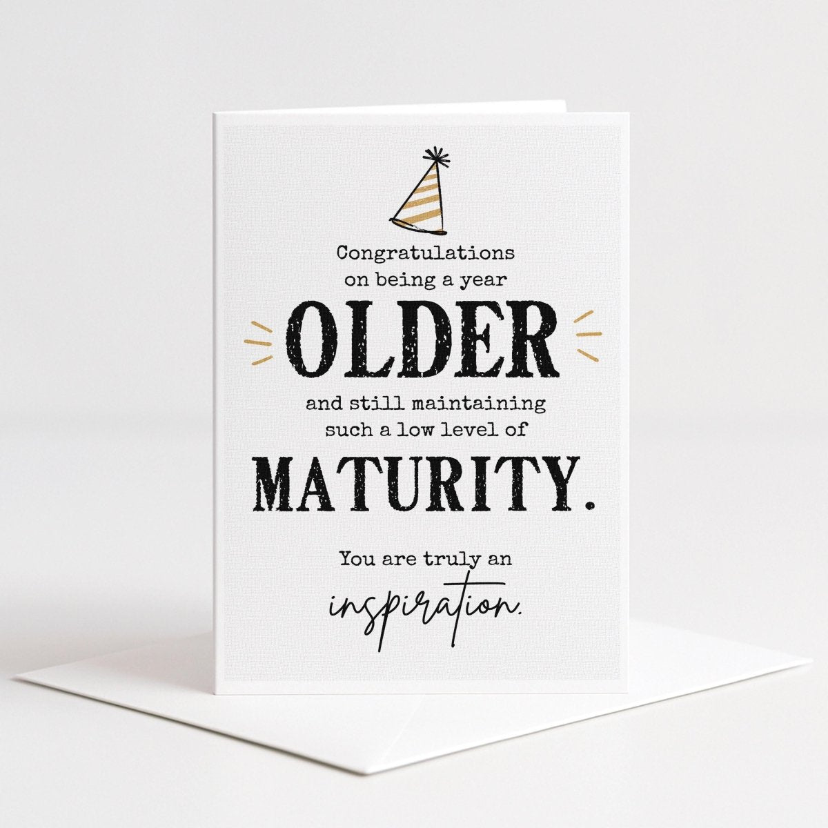 The image is a greeting card celebrating the achievements of an older person, congratulating them on being a year older and still maintaining a low level of maturity.
