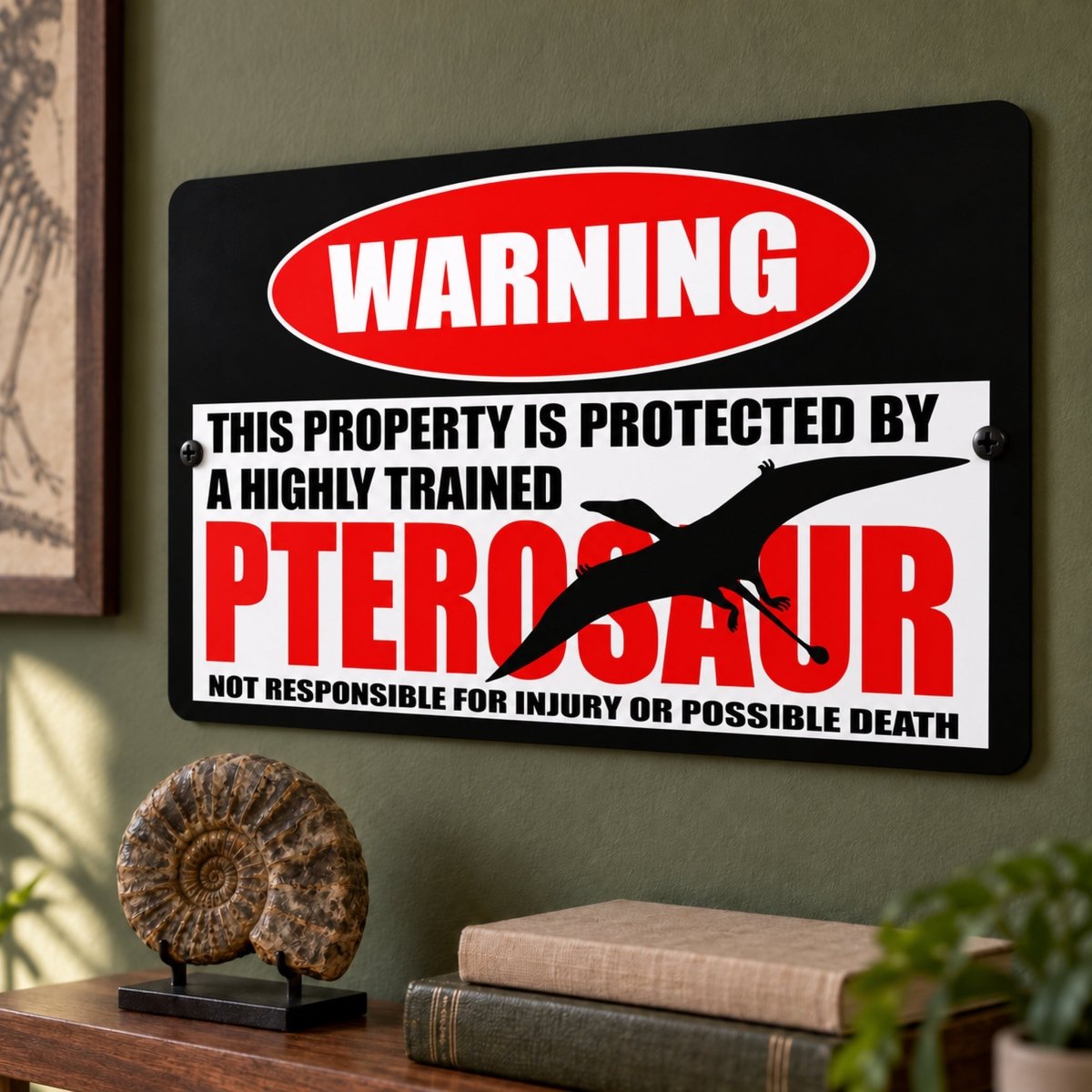 Pterosaur metal warning sign on a wall above a small fossil and a stack of books, with its full warning text