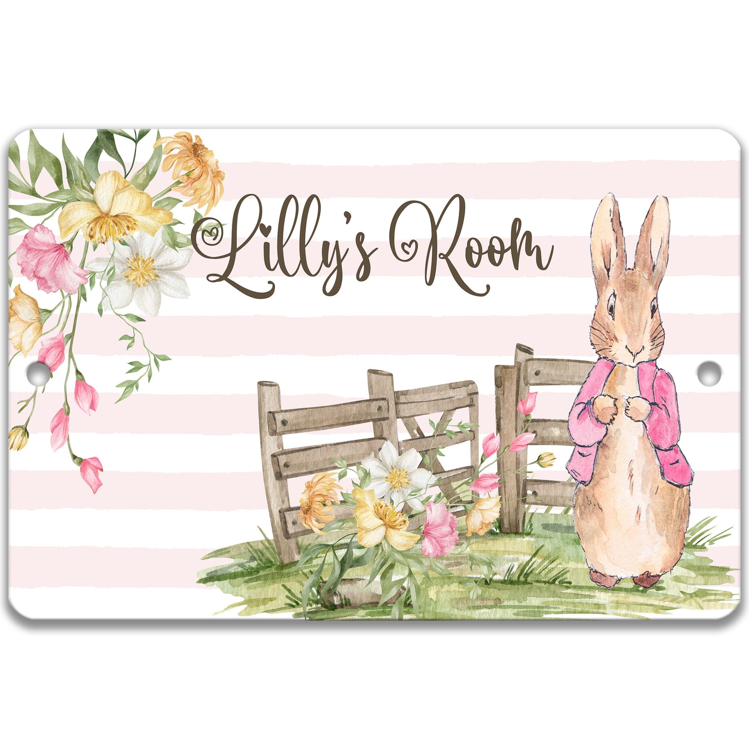 A sign with a bunny rabbit and flowers, along with the text "Lilly's Room" written on it.