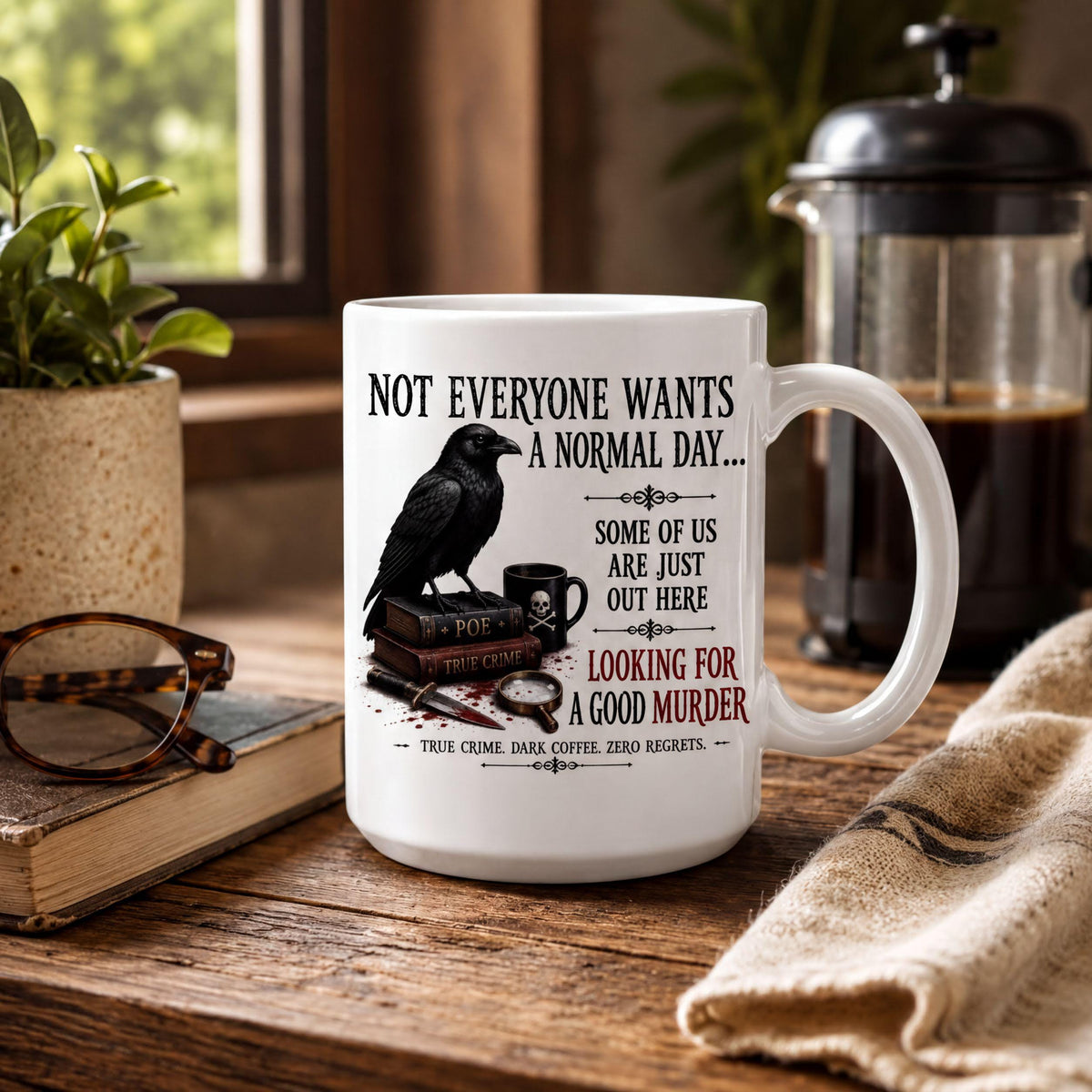 True crime raven mug on a rustic table with reading glasses, an old book, a French press and a burlap towel
