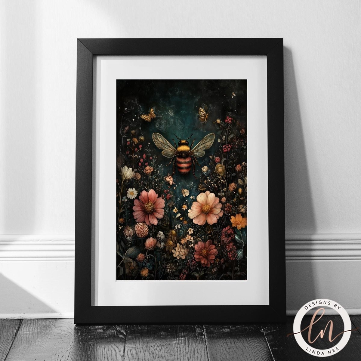 A framed art print featuring a detailed illustration of a bumblebee surrounded by a dense field of colorful wildflowers on a dark background, styled leaning against a white wall on a dark wood floor.