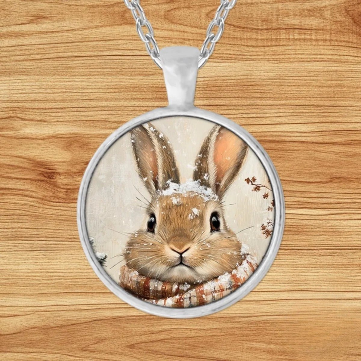 Round silver charm pendant necklace featuring a bunny bundled in a plaid scarf in a quiet snowy woodland