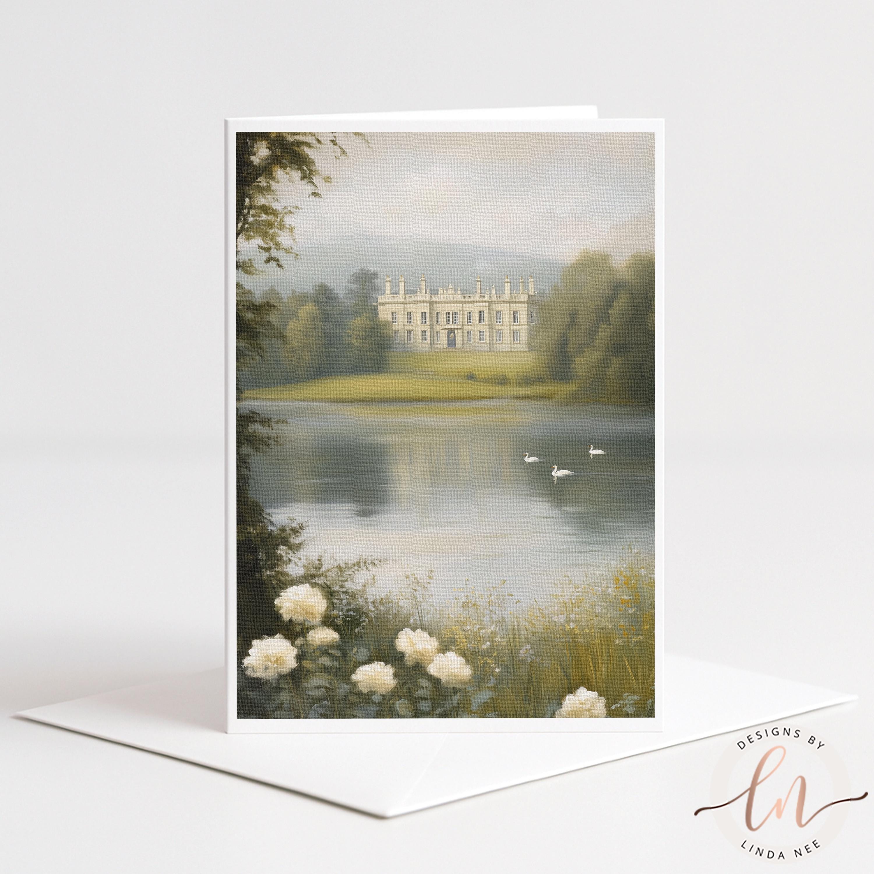 A vertical greeting card or art print featuring a scenic landscape painting of a large estate mansion by a calm lake, with swans, trees, and white flowers in the foreground. The card is displayed upright on a white envelope against a clean white background.