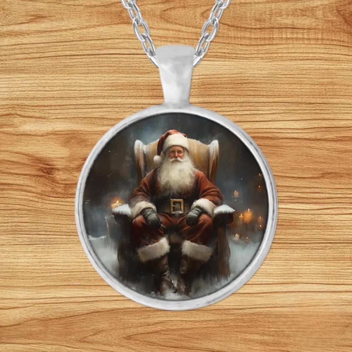 Round silver charm pendant necklace featuring a contemplative Father Christmas seated in a wing-back armchair surrounded by glowing candlelight