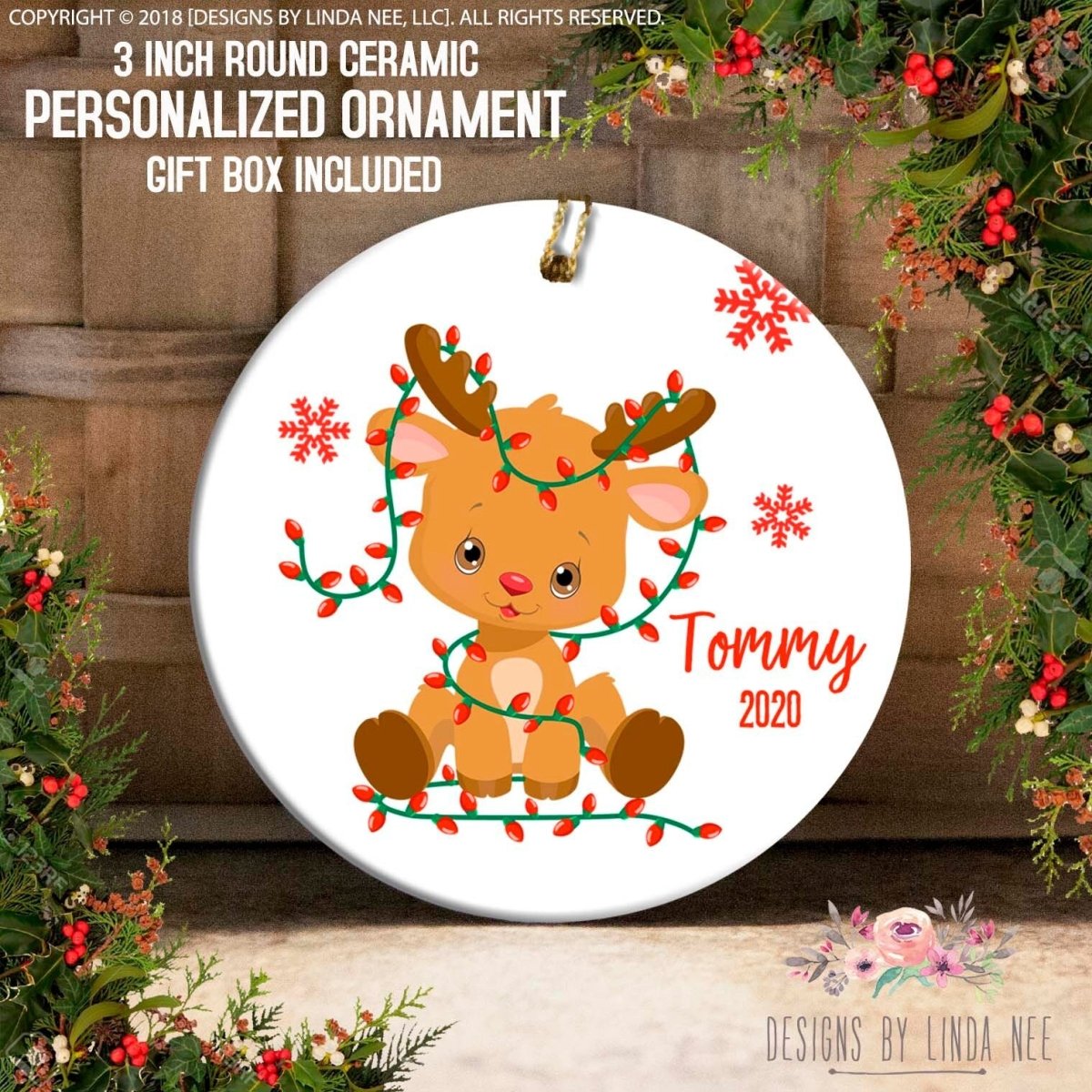 A 3-inch ceramic ornament featuring a cartoon reindeer with a personalized name, "Tommy", and the year "2020", surrounded by Christmas lights and greenery.
