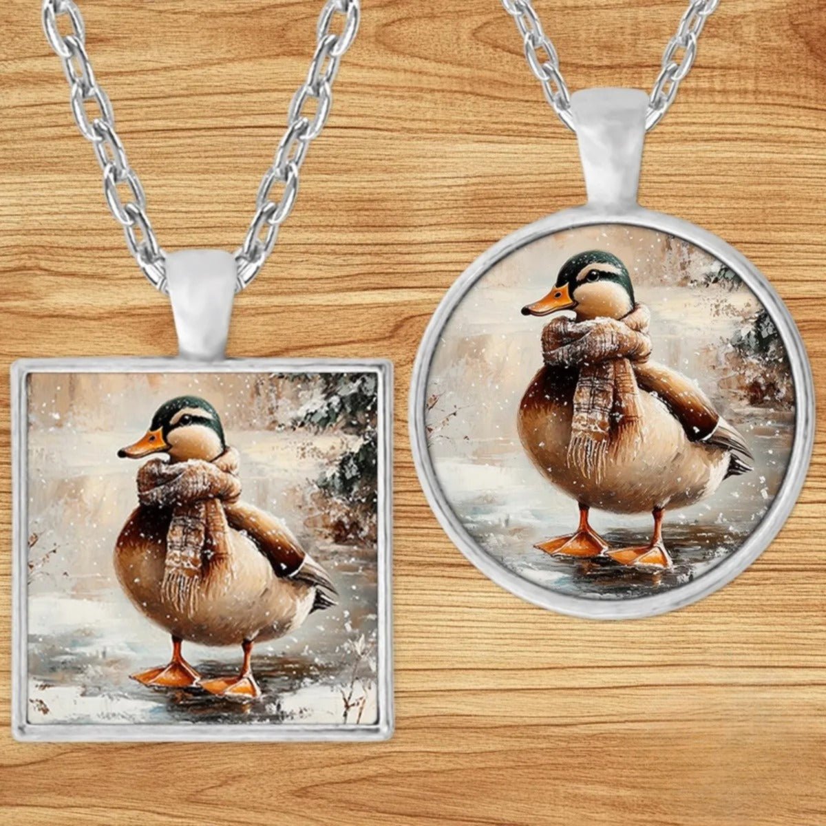 Duck in a Plaid Scarf pendant necklace shown in round and square silver charm styles on a wood background