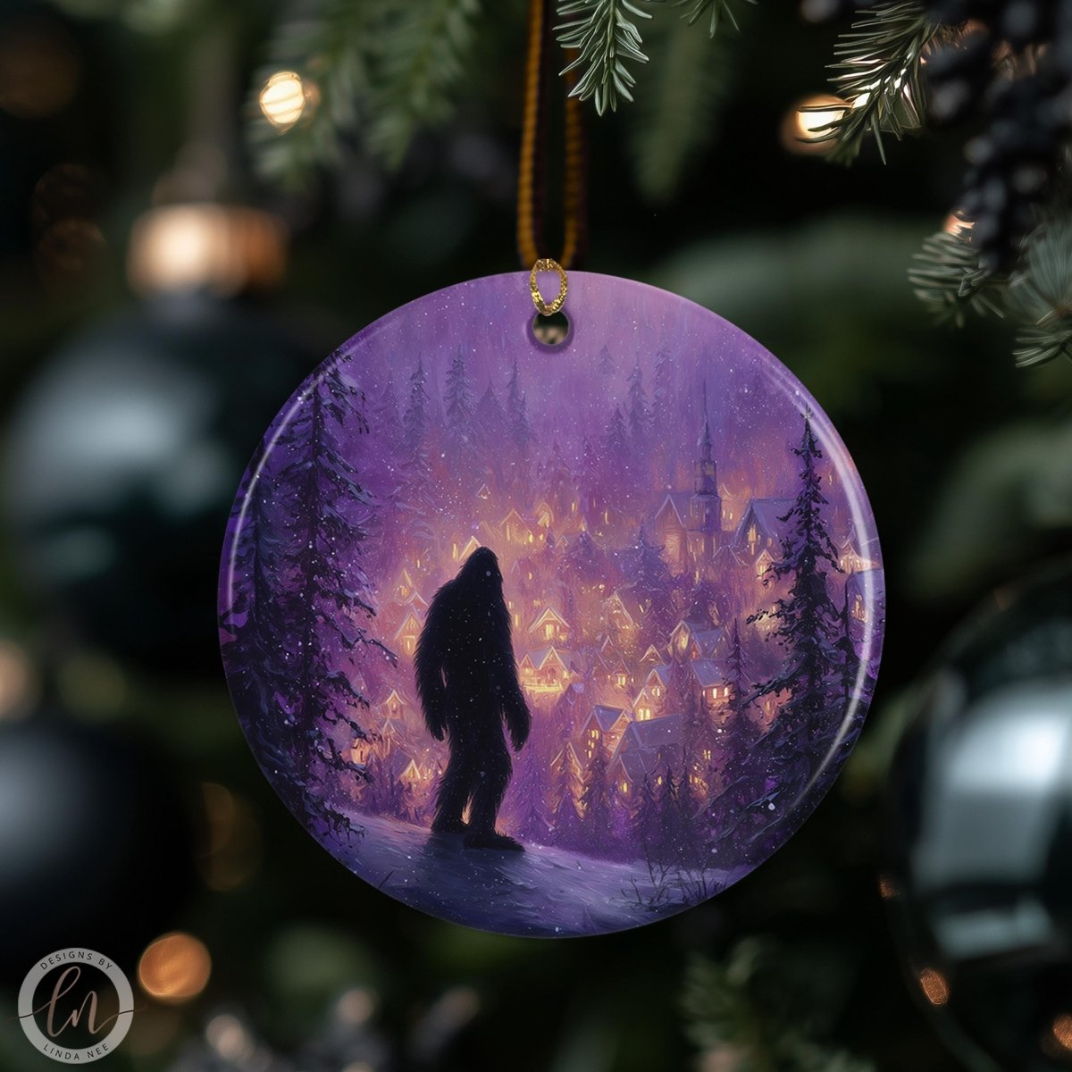 A purple ornament featuring a silhouetted figure of a Sasquatch standing in a snowy village scene, with a snowy village and trees in the background.