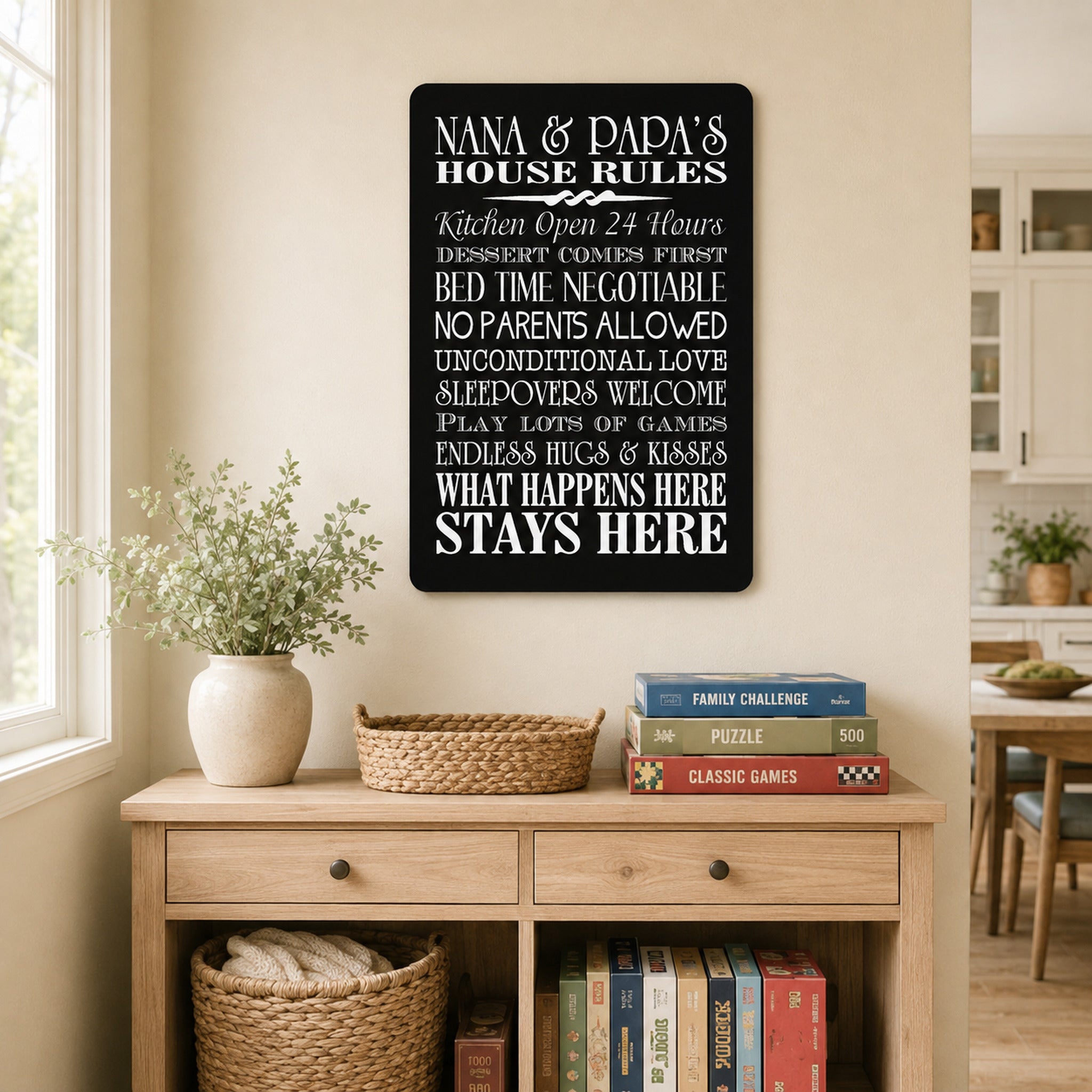 a black sign with white text hanging on a wall, which appears to be a list of rules or guidelines for a house. Below the sign, there is a wooden dresser with a potted plant, a stack of books, and a basket.