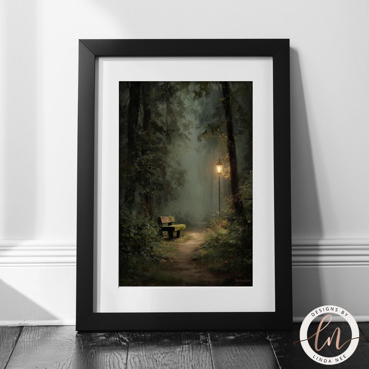 A black-framed painting depicting a serene forest scene with a bench in the distance, surrounded by lush greenery and a path leading through the trees.