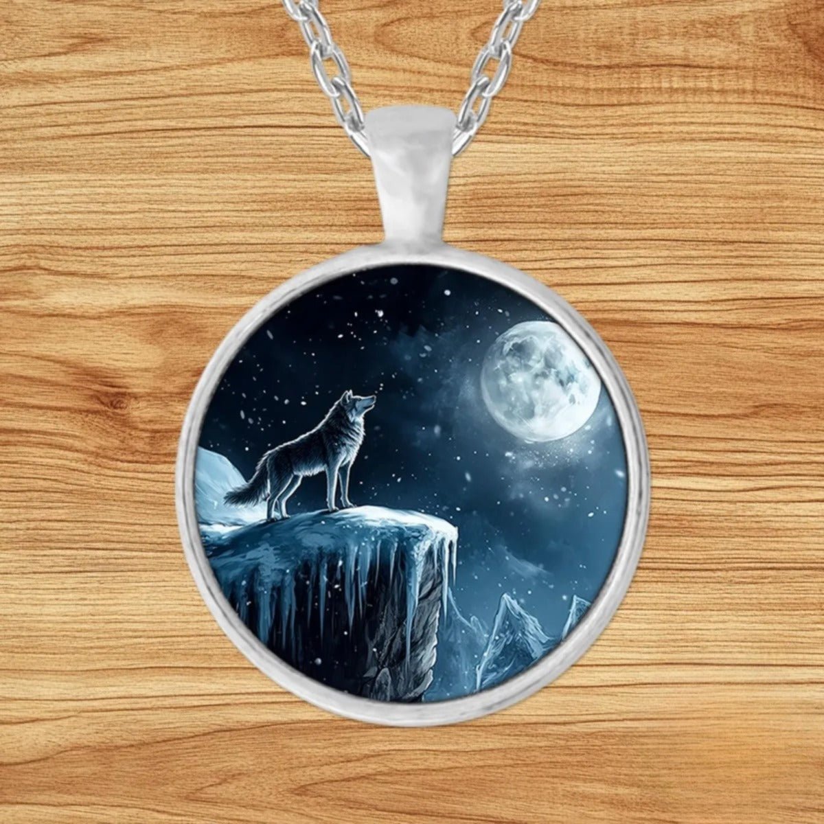 Round silver charm pendant necklace featuring a wolf standing on a snowy cliff beneath a glowing full moon