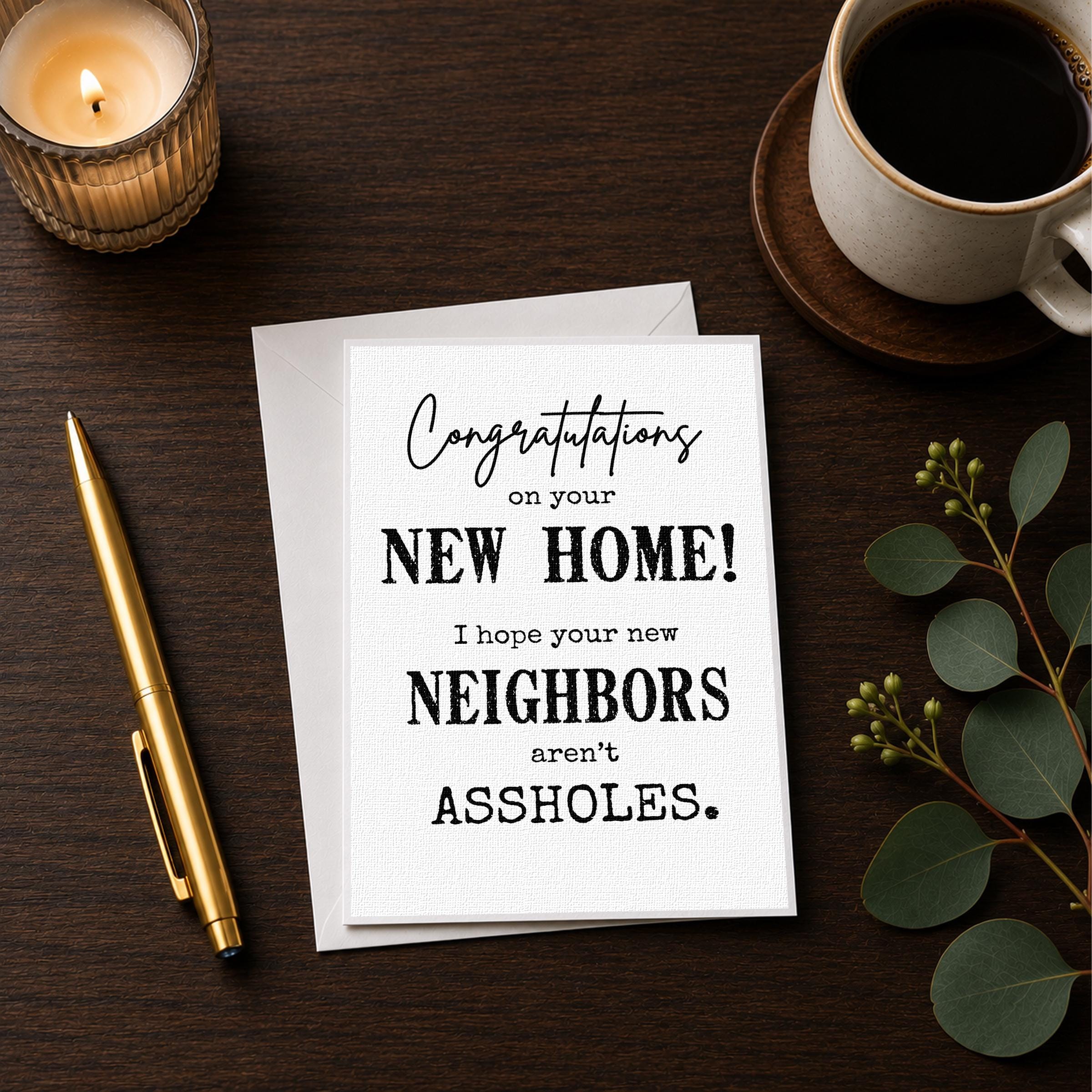 a card with a humorous message, a candle, a pen, and a cup of coffee on a wooden surface.