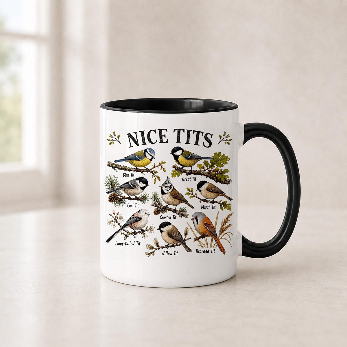 Nice Tits bird mug in the 11 oz black handle version with a black interior, on a light counter by a window