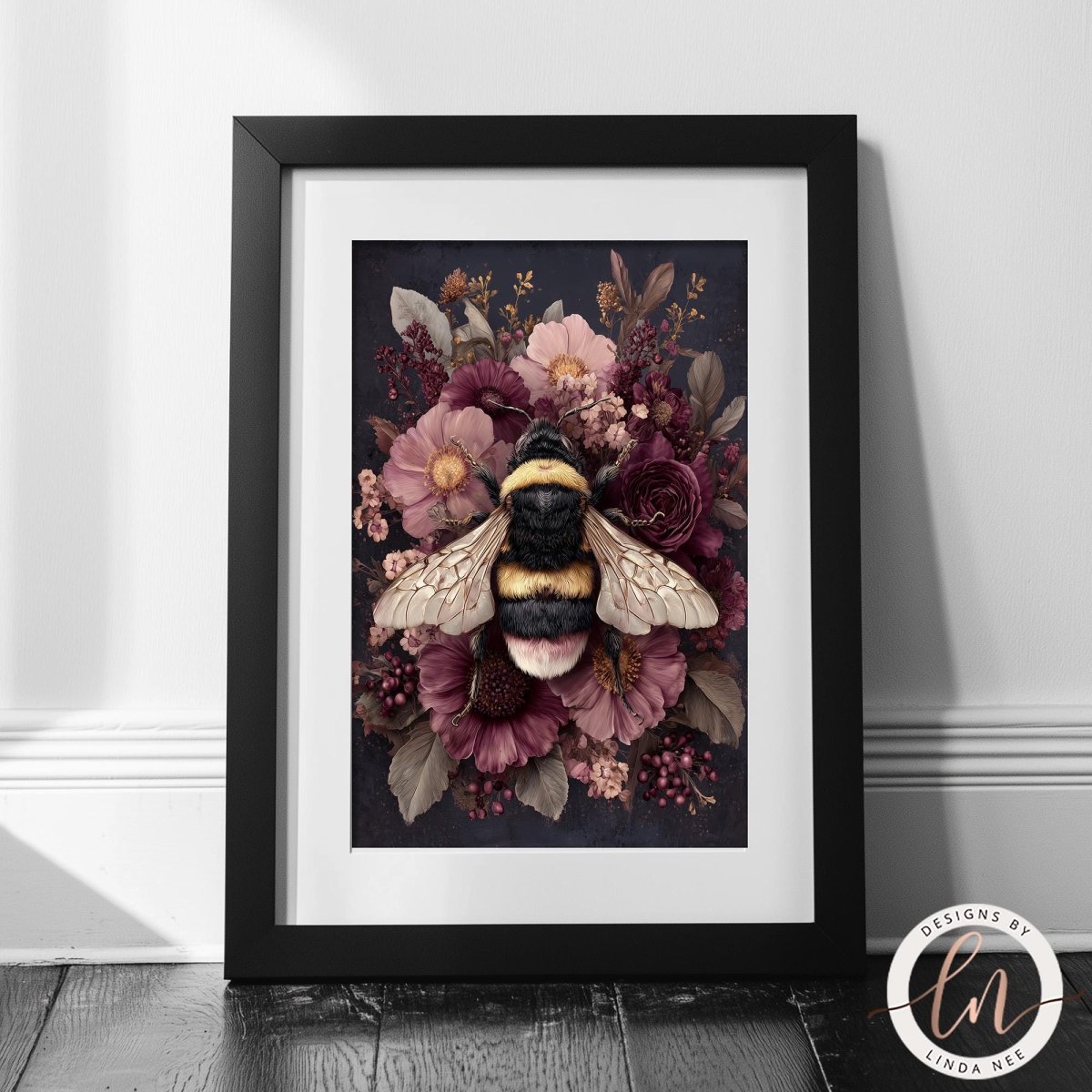 A framed print depicting a bee surrounded by a vibrant floral arrangement, including pink and purple flowers, against a dark background.
