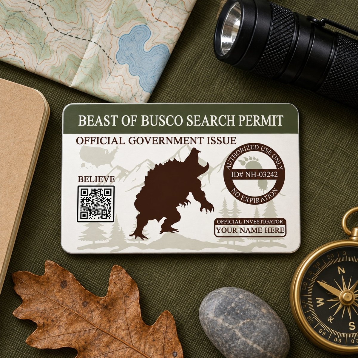 a "BEAST OF BUSCO SEARCH PERMIT" official government identification card, along with various outdoor items such as a compass, a leaf, and a rock.