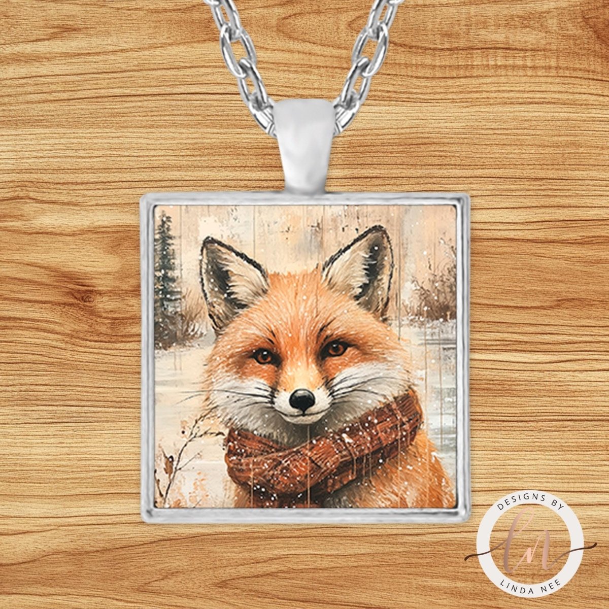 A square pendant necklace with a framed image of a fox wearing a scarf.