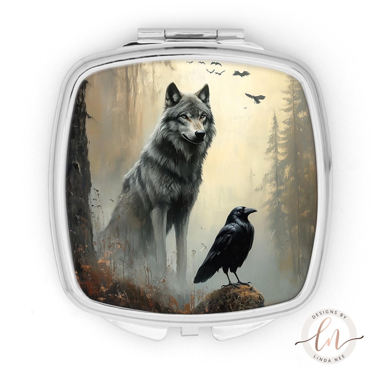 A silver compact mirror with a painting of a wolf and a black crow in a forest setting.