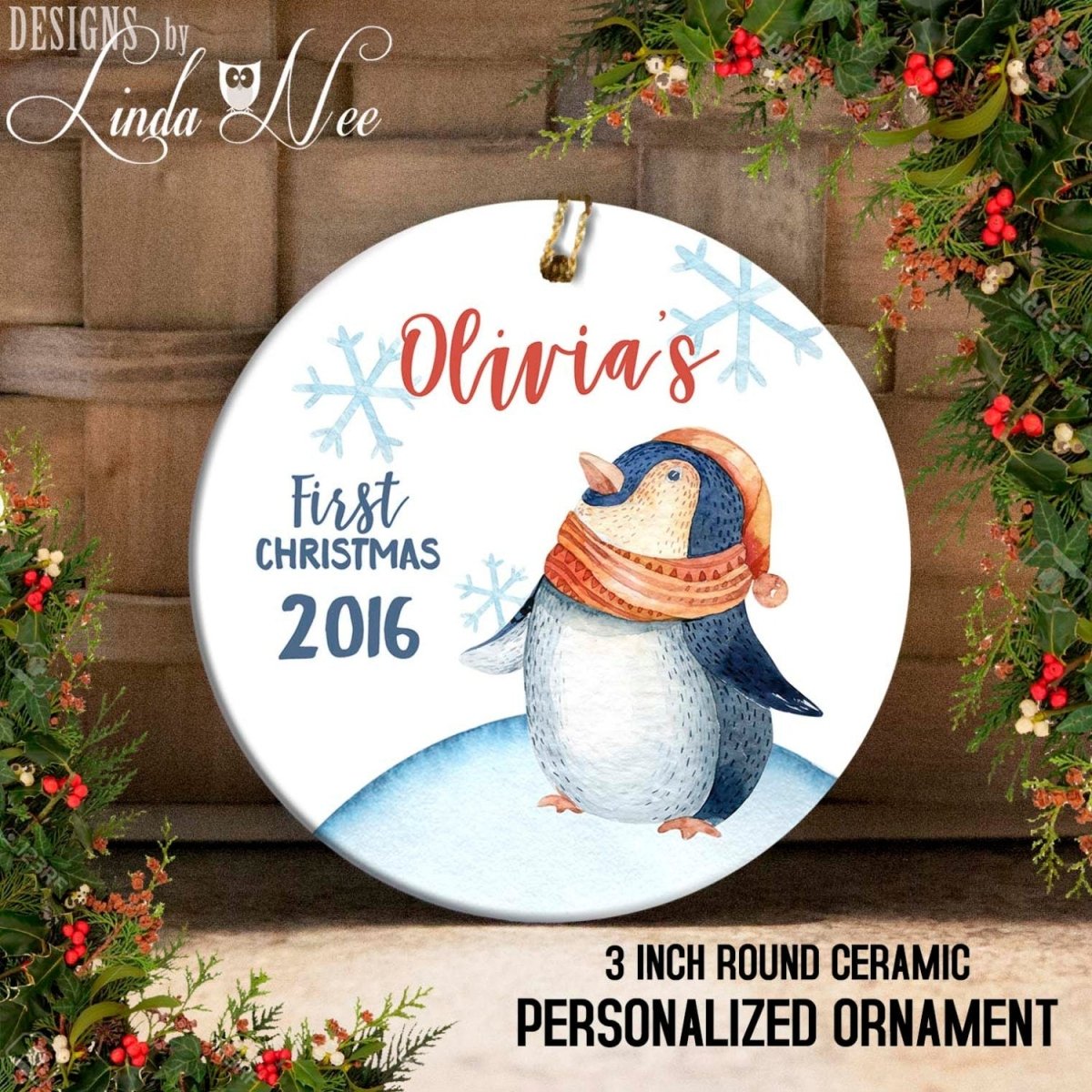 Personalized Christmas ornament with penguin design and text 'Olivia's First Christmas 2016' on a decorative background.