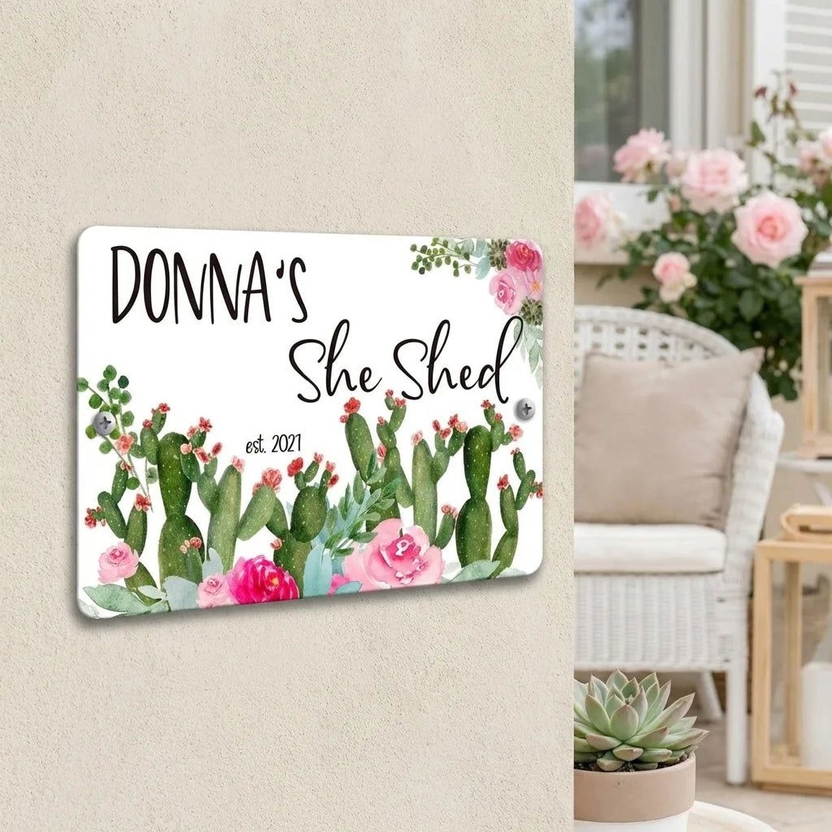 a sign that reads "DONNA'S She Shed" with a floral design, hanging on a wall.