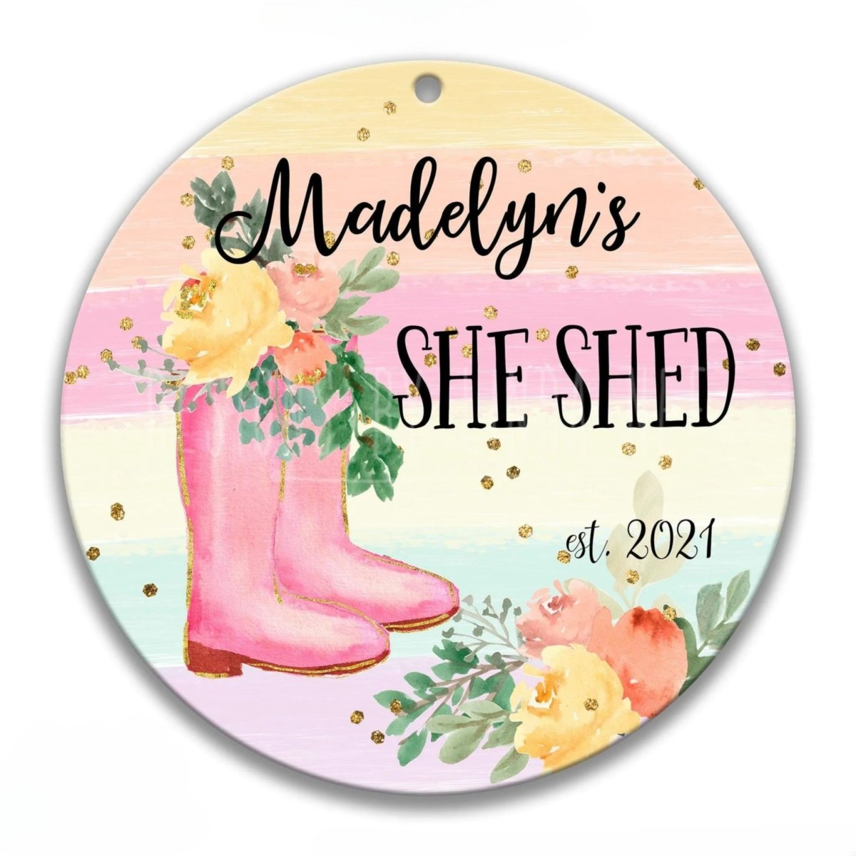 The image is a round sign with a floral design and text, featuring a pair of pink rain boots and colorful flowers.