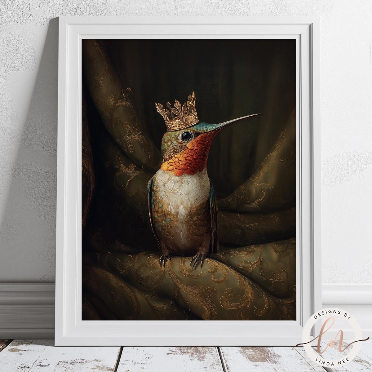 A framed painting depicting a colorful hummingbird wearing a golden crown, perched on a green fabric with a gold pattern.