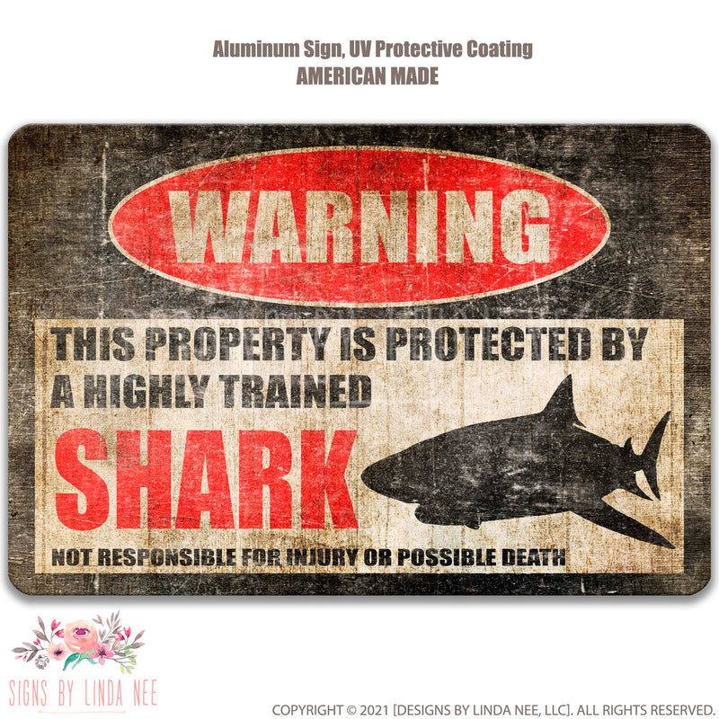Distressed background with font saying Warning This Property is Protected by a Highly trained Shark Not responsible for injury or possible death Sign